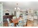A dining room with hardwood floors, a chandelier, and an open view to a living space and modern kitchen at 240 China Grove Rd, China Grove, NC 28123