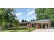 Charming single-story brick home featuring a covered porch and a well-manicured front yard with mature trees at 240 China Grove Rd, China Grove, NC 28123