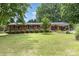 Traditional brick ranch featuring a covered porch, manicured lawn, and symmetrically planted bushes at 240 China Grove Rd, China Grove, NC 28123