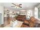 Open-concept living space with hardwood floors, ceiling fans, and an adjacent kitchen with a granite countertop island at 240 China Grove Rd, China Grove, NC 28123