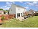 A spacious backyard with a patio area, pergola, green lawn, and a wooden fence for privacy at 2636 Forest Grove Ct, Charlotte, NC 28269