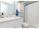Bright bathroom featuring a marble sink, white cabinets, and a shower with a patterned white curtain at 2636 Forest Grove Ct, Charlotte, NC 28269