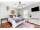 Cozy bedroom with hardwood floors, ceiling fan, bed with soft purple blanket, and plants for decor at 2636 Forest Grove Ct, Charlotte, NC 28269