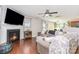 Comfortable living room with a fireplace, mounted TV, hardwood floors, and a ceiling fan at 2636 Forest Grove Ct, Charlotte, NC 28269