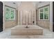 Luxurious bathroom featuring marble accents, large windows, and a soaking tub for ultimate relaxation and pampering at 2926 Crane Rd, Waxhaw, NC 28173