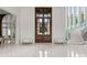 Bright foyer features marble floors, large wood doors, a curved staircase, and a windowed archway at 2926 Crane Rd, Waxhaw, NC 28173