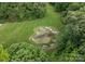 Unique pond shaped like a bear paw print nestled in a lush green lawn and surrounded by mature trees at 2926 Crane Rd, Waxhaw, NC 28173