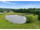 Scenic aerial shot of a tranquil pond on a large property, surrounded by lush greenery and trees at 2926 Crane Rd, Waxhaw, NC 28173