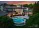 Wonderful view of the outdoor pool area at twilight with lush landscaping and lighting at 2926 Crane Rd, Waxhaw, NC 28173