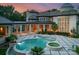 Luxury pool and spa on a rear patio with travertine tile and stone columns at 2926 Crane Rd, Waxhaw, NC 28173