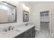 Bright bathroom featuring a double sink vanity, walk-in closet, white walls, and modern fixtures at 3020 Brooks Mill Ln, Wingate, NC 28174