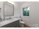 Well-lit bathroom with a gray vanity and a view of the outdoors at 3020 Brooks Mill Ln, Wingate, NC 28174