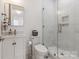 Modern bathroom with white vanity, toilet, and a glass-enclosed shower with marble tiling at 3020 Brooks Mill Ln, Wingate, NC 28174