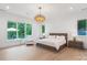 Bright bedroom with a chandelier, large windows offering views of the outdoors, and a cozy sitting area at 3020 Brooks Mill Ln, Wingate, NC 28174