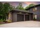Exterior view of a two-car brick garage with black doors, connected to the house by stone at 3020 Brooks Mill Ln, Wingate, NC 28174
