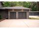 The exterior of a two-car brick garage with black doors, and a three-car garage in background at 3020 Brooks Mill Ln, Wingate, NC 28174