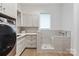 Modern laundry room featuring a washer and dryer, ample cabinet space, and a convenient dog-washing station at 3020 Brooks Mill Ln, Wingate, NC 28174