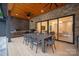 Inviting outdoor dining area with a built-in grill, stone wall, and wood ceiling at 3020 Brooks Mill Ln, Wingate, NC 28174