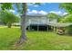 Back of the home featuring a back deck, a shaded area and lush green grass at 3400 Reid Ave, Charlotte, NC 28208