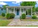 Inviting home with a quaint front porch, complemented by verdant landscaping and a stone walkway at 3400 Reid Ave, Charlotte, NC 28208