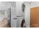 Laundry area featuring stacked washer and dryer with a blue-grey refrigerator to the side at 3400 Reid Ave, Charlotte, NC 28208