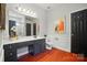 Stylish bathroom with dark cabinets and striking red hardwood floors at 3912 Grace Ct, Indian Trail, NC 28079