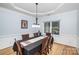 Formal dining area with hardwood floors, modern lighting, and wainscoting at 4716 Heatherton Pl, Charlotte, NC 28270