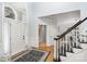 Elegant entryway with a patterned rug, white front door with transom, and a staircase at 4716 Heatherton Pl, Charlotte, NC 28270