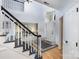 Spacious entryway with hardwood floors, black and white staircase, and views into the living room at 4716 Heatherton Pl, Charlotte, NC 28270