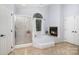 Bright main bathroom featuring a fireplace, tub, and glass shower at 4716 Heatherton Pl, Charlotte, NC 28270