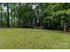 Lush backyard with a shed and a wooden deck, offering privacy and a serene atmosphere at 5233 Great Wagon Rd, Charlotte, NC 28215