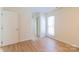 A cozy bedroom featuring hardwood floors, white walls, and bright window at 5233 Great Wagon Rd, Charlotte, NC 28215