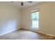 Well-lit bedroom showcasing hardwood floors, white walls, and a large window at 5233 Great Wagon Rd, Charlotte, NC 28215