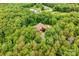 Areal view showcasing a secluded home surrounded by lush trees, with pool, deck, and outdoor living spaces at 560 Blue Sky Dr, Dallas, NC 28034