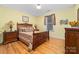 Cozy bedroom with warm yellow walls, hardwood floors, and classic wooden furniture, bathed in natural light at 560 Blue Sky Dr, Dallas, NC 28034