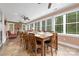 Bright sunroom dining area featuring large windows, stone accent wall with fireplace, and tiled flooring at 560 Blue Sky Dr, Dallas, NC 28034