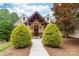 Inviting front porch with wooden beams and an American flag, flanked by manicured greenery and mature trees at 560 Blue Sky Dr, Dallas, NC 28034