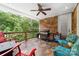 Outdoor patio with stone floor, brick accent wall, ceiling fan, and comfortable seating with wooded view at 560 Blue Sky Dr, Dallas, NC 28034