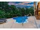 Backyard in-ground pool with slide and lounge chairs, surrounded by lush greenery and outdoor lighting at 560 Blue Sky Dr, Dallas, NC 28034