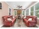 Cozy sunroom featuring tiled floors, stone accent wall with fireplace, and comfortable seating, bathed in natural light at 560 Blue Sky Dr, Dallas, NC 28034