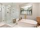 Modern bathroom features a glass-enclosed shower and a soaking tub with stylish fixtures at 5721 Ballinard Ln, Charlotte, NC 28277