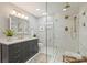 Beautiful bathroom featuring a spacious glass shower, dual shower heads, modern fixtures and gray vanity at 5721 Ballinard Ln, Charlotte, NC 28277