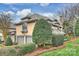 Side view of a tan home featuring an attached garage and beautiful landscaping at 5721 Ballinard Ln, Charlotte, NC 28277