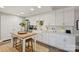 A kitchen featuring white cabinets, marble countertops, farmhouse sink, and center island with seating at 5721 Ballinard Ln, Charlotte, NC 28277