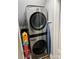 A laundry area featuring a stacked washer and dryer unit with storage shelves at 5721 Ballinard Ln, Charlotte, NC 28277