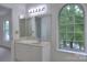 Bathroom featuring a large mirror over the vanity, ample lighting, and an arched window at 6310 Trevor Simpson Dr, Indian Trail, NC 28079