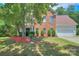 Charming brick home featuring manicured landscaping, a well-kept lawn, and a two-car garage at 6310 Trevor Simpson Dr, Indian Trail, NC 28079
