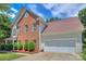 A two-story home featuring a brick facade, attached garage, well-manicured yard, and architectural interest at 6310 Trevor Simpson Dr, Indian Trail, NC 28079