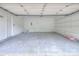 A spacious two-car garage features overhead lighting, a service door, and built in shelving at 6310 Trevor Simpson Dr, Indian Trail, NC 28079