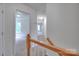 Hallway featuring wood railing and an entry to a bedroom area with a window at 6310 Trevor Simpson Dr, Indian Trail, NC 28079